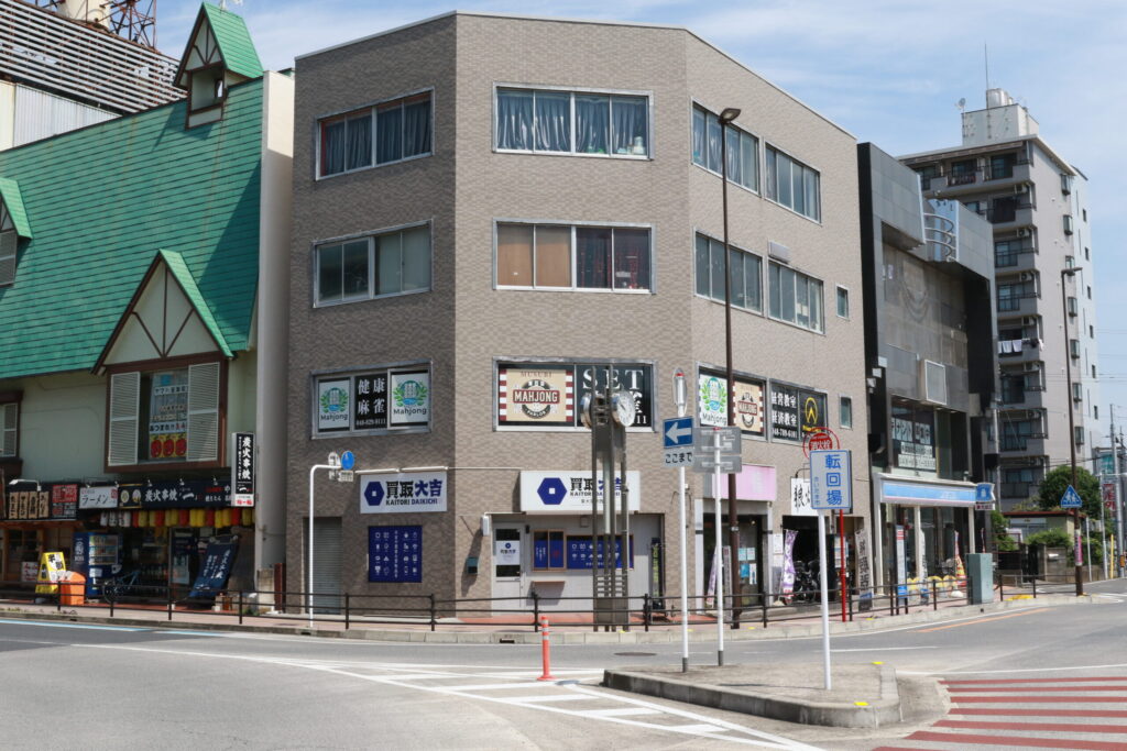 駅前に立地する健康麻雀サロンの入るビル外観。大きな『健康麻雀』の看板が目印でアクセスも良好